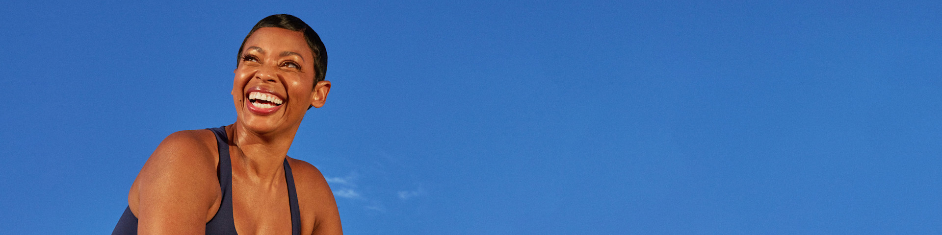 Woman over 50 years old smiling big up into the sky.