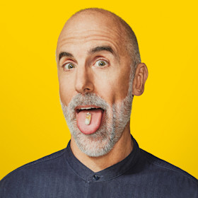 Photo of a smiling man with a single multivitamin on his tongue