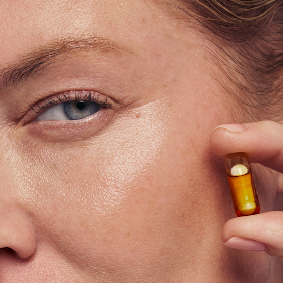 Model holding HyaCera capsule up to face